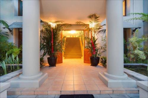 a hallway of a house with columns and stairs at Tropical One Bedroom Apartment at The Mediterranean in Port Douglas