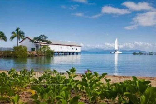 a house on the shore of a body of water at Tropical One Bedroom Apartment at The Mediterranean in Port Douglas