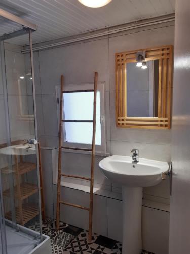 La salle de bains est pourvue d'un lavabo et d'un miroir. dans l'établissement Maison avec 2 chambres est un Gîte Brugière et maison une chambre est une chambre d'hôtes, à Murat-le-Quaire