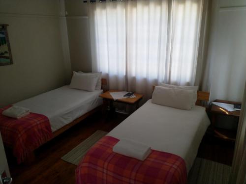 a small room with two beds and a window at Crane Cottage in Colesberg