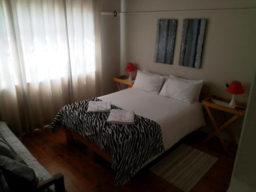 a bedroom with a bed with a zebra print blanket at Crane Cottage in Colesberg