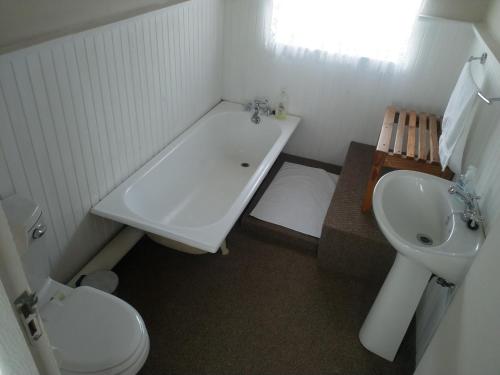 a bathroom with a sink and a tub and a toilet at Crane Cottage in Colesberg