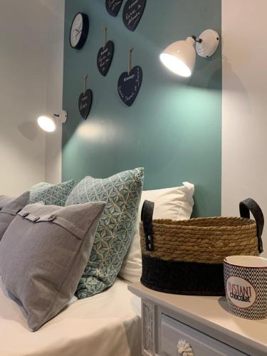 a room with a bed with pillows and clocks on the wall at Hotel Les Embruns in Le Touquet-Paris-Plage