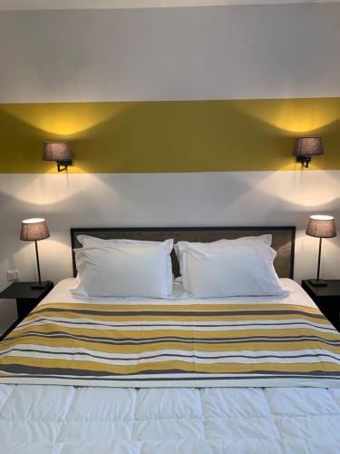 a bedroom with a large bed with two lamps at Hotel Les Embruns in Le Touquet-Paris-Plage