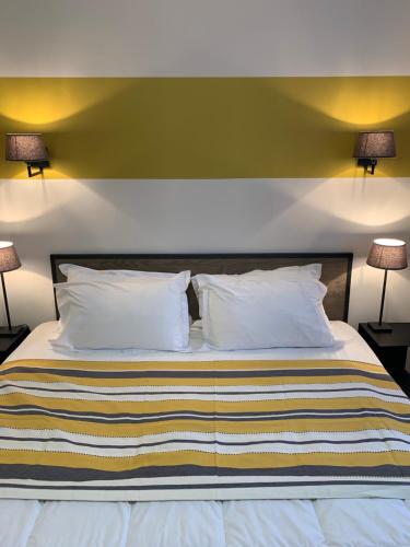 a bedroom with a bed with two lamps on two tables at Hotel Les Embruns in Le Touquet-Paris-Plage
