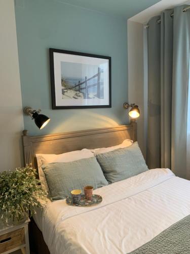 a bed with a tray with two cups on it at Hotel Les Embruns in Le Touquet-Paris-Plage