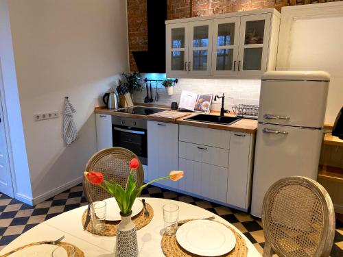 uma cozinha com uma mesa e cadeiras e um frigorífico em Villa Nordic em Dornum
