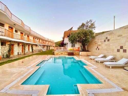 a swimming pool in the courtyard of a building at Alaçatı Barbarossa Hotel in Cesme