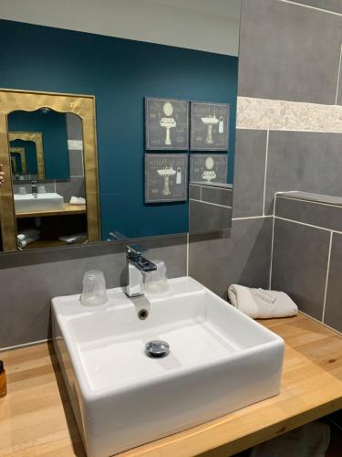 a bathroom with a white sink and a mirror at Hotel Les Embruns in Le Touquet-Paris-Plage