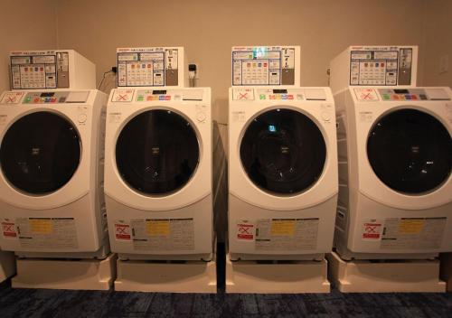 four washing machines are lined up in a room at Urban Hotel Kyoto Gojo Premium in Kyoto