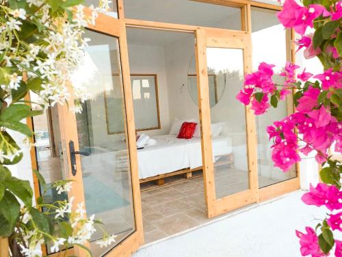 a room with a bed and a glass door with flowers at Alaçatı Barbarossa Hotel in Cesme