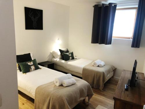 - une chambre avec 2 lits et des serviettes dans l'établissement Yeti Lodge Chalets & Apartments, à Chamonix-Mont-Blanc