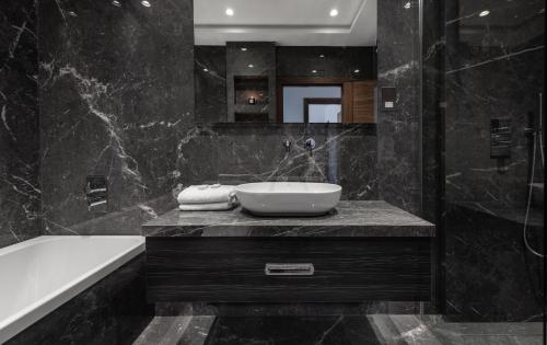 a bathroom with a bath tub and a sink at Hux Hotel, Kensington in London