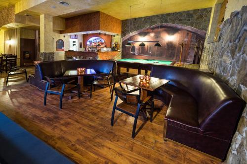a bar with leather seats and tables in a room at Dwór Ostoia in Rymanów