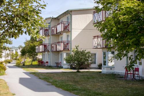 ein Gebäude mit roten Balkonen an der Seite in der Unterkunft Ravinstigen - Visby Lägenhetshotell in Visby