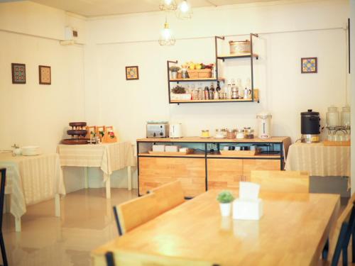 a room with a table and two tables and a kitchen at I-Home Residence and Hotel in Pluak Daeng