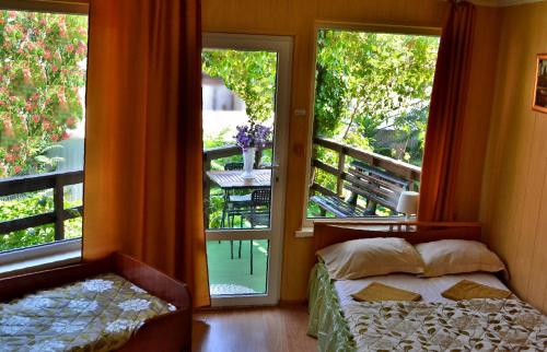 a bedroom with a bed and a view of a balcony at Domik u Plyazha Guest House in Gelendzhik