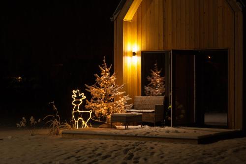 a christmas tree and a reindeer in front of a building at Widok na Śnieżkę - domki całoroczne in Łomnica