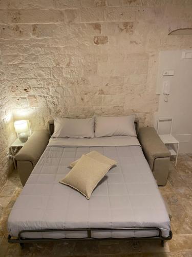 a bed in a room with a brick wall at AD HOUSE - Living Room in Castellana Grotte