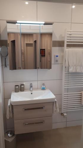 ein Badezimmer mit einem weißen Waschbecken und einem Spiegel in der Unterkunft 4-Sterne Ferienwohnung Carbach -Perfekt für Radfahrer- in Boppard