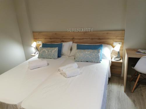 a large white bed with two pillows on it at Km101 in Baamonde