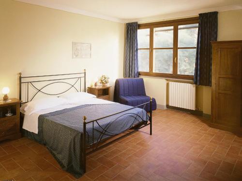 1 dormitorio con 1 cama, 1 silla y 1 ventana en Tenute di Badia, en Altopascio