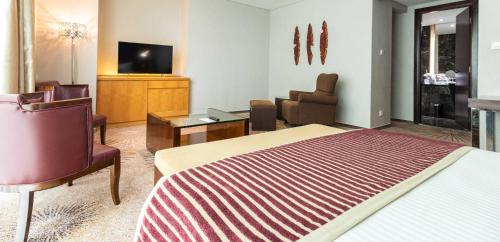 a hotel room with a bed and a tv at Cambridge Hotel Medan in Medan