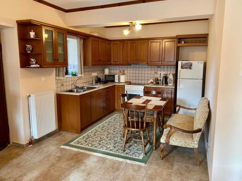 uma cozinha com armários de madeira e uma mesa com cadeiras em Comfortable Apartment in Village Saint Minas em Ágios Minás