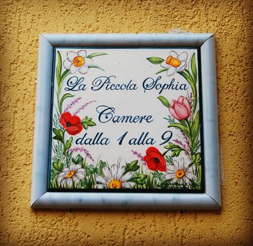 a picture of a sign on a wall with flowers at Hotel Villa Sophia in Sanremo