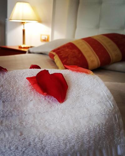a red heart on a white blanket on a bed at Hotel Villa Sophia in Sanremo