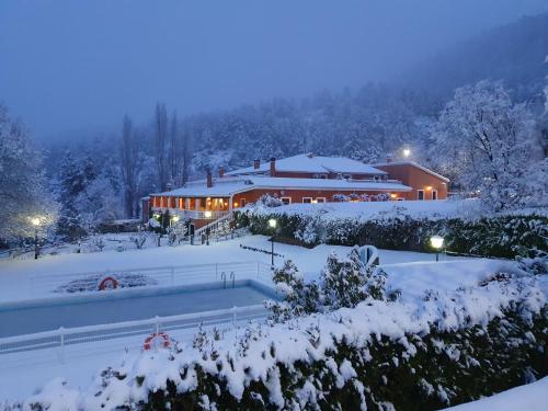 a building covered in snow at night at Hospedium Hotel Val de Pinares in Bogarra