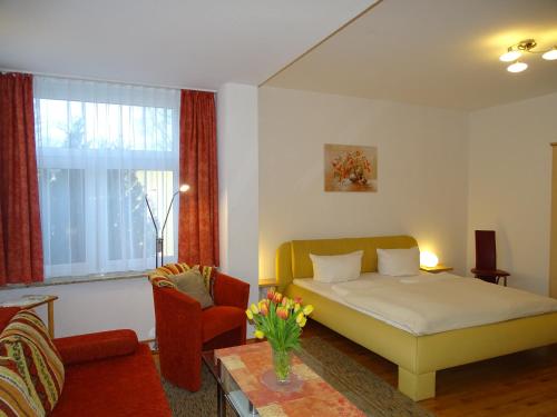 a bedroom with a bed and a couch and a chair at Ferienwohnungen Stranddistel - Apartments von 30 bis 75 qm in Zinnowitz