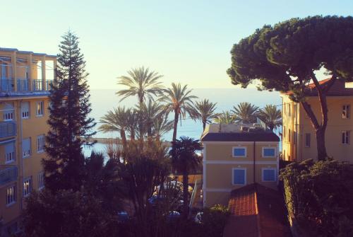 a view of buildings and palm trees and the ocean at Hotel Villa Sophia in Sanremo