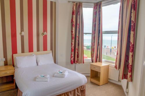 a bedroom with a bed and a large window at Baytree Hotel in Llandudno