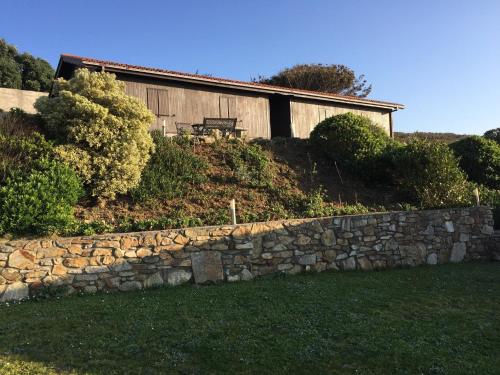 a stone wall in front of a house at Bungalow 2 (adosado) - Playa Arnela in Carballo