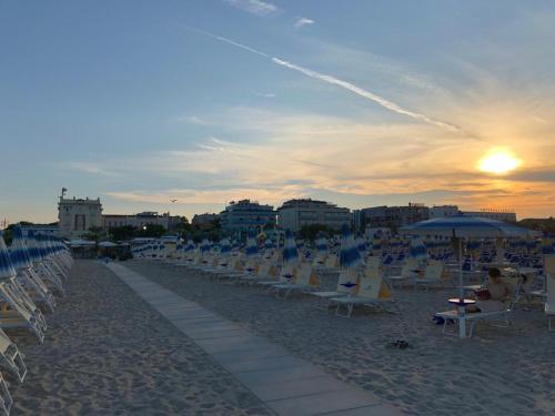 a group of chairs and umbrellas on a beach at Grand Hotel Cesenatico in Cesenatico