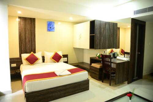 a bedroom with a bed and a desk and a table at Miles Inn Hotel in Hassan