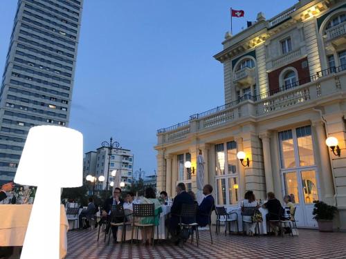 a group of people sitting at tables in front of a building at Grand Hotel Cesenatico in Cesenatico