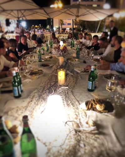 a group of people sitting at a long table at Grand Hotel Cesenatico in Cesenatico