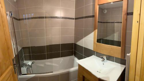 a bathroom with a sink and a bath tub at Boost Your Immo Vars Chalet Des Rennes 210 in Vars