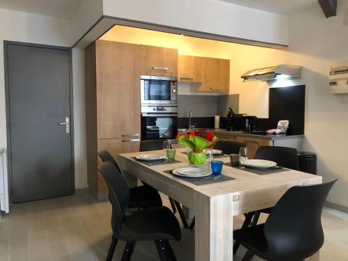 une cuisine avec une table en bois et des chaises ainsi qu'une salle à manger dans l'établissement LES APPART's DES THERMES, à Rochefort