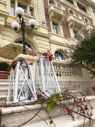 a building with a street light and flowers in front of it at Grand Hotel Cesenatico in Cesenatico