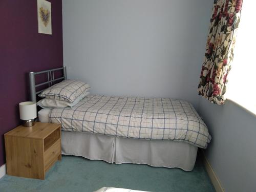 a small bedroom with a bed and a night stand at Little Owls Nest Holiday Home in Wisbech