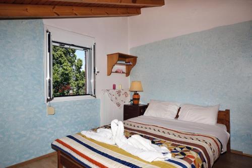 Villa Areti - A Cottage in the Cretan Nature في Kántanos: غرفة نوم بسرير وملاءات بيضاء ونافذة