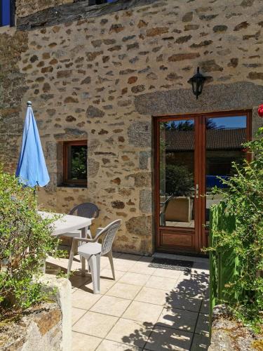a patio with a table and an umbrella next to a building at Domaine de la Ribiere in Pagéas