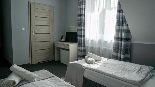 a hotel room with two beds and a window at Ośrodek LZS CIS "Od Nowa" in Mielno