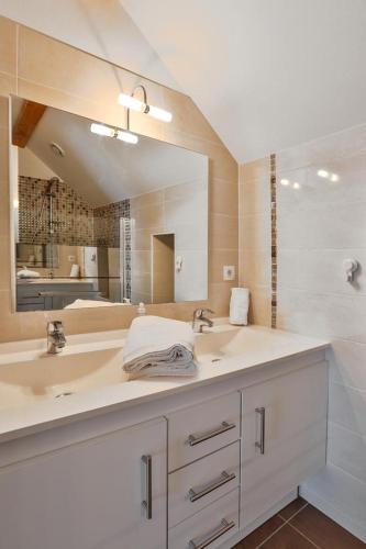 une salle de bain avec deux lavabos et un grand miroir dans l'établissement Comtesse de Dordogne, à Les Eyzies-de-Tayac