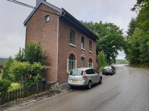 two cars parked on the side of a brick building at VILLA GABRIEL in Trois-Ponts