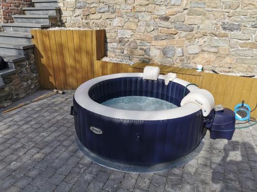 a jacuzzi tub in front of a stone wall at VILLA GABRIEL in Trois-Ponts