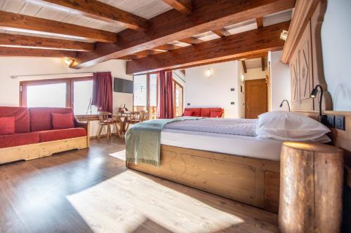 a bedroom with a large bed and a living room at Alpino Lodge Bivio in Livigno